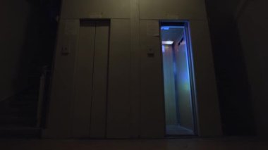 Asansör kapıları boş bir katta açılıp kapanıyor ve içinde disko ışıkları yanıp sönüyor. Parti anlayışı. Stok görüntüleri. Gece kulübünde alışılmadık asansörler var..