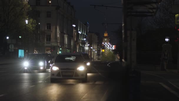 Noite de verão vista urbana de carros raros dirigindo lentamente na estrada. Imagens de stock. Tráfego noturno na cidade, movendo carros ao longo de edifícios e casas no fundo do céu escuro. — Vídeo de Stock