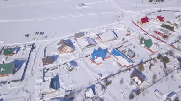 Αεροφωτογραφία του χιονιού κάλυψε την πόλη και τους δρόμους το χειμώνα, Ελβετία περιοχή υπαίθρου. Κλιπ. Εξοχικά με φωτεινά στέγες που βρίσκονται κοντά χιονισμένο λευκό πεδίο σε μια ηλιόλουστη μέρα του καλοκαιριού. — Αρχείο Βίντεο