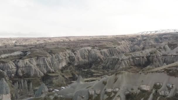 Vista aérea de Capadocia, cámara moviéndose hacia atrás y revelando las montañas y casas dentro de ellas. Acción. Fondo natural de colinas y formaciones rocosas. — Vídeo de stock