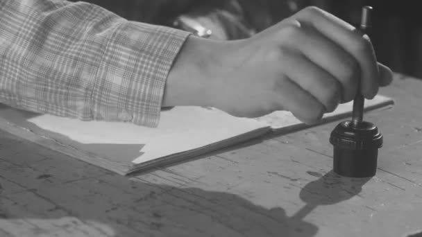 Homem sentado em uma mesa e usando caneta fonte retro e tintas para fazer anotações. Imagens de stock. Feche a mão masculina mergulhando sua caneta em tintas e começando a escrever algo em um caderno de papel, vintage — Vídeo de Stock