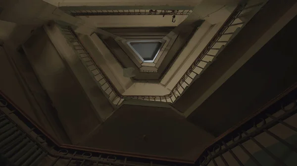 楼梯和许多楼层的底部是老式铁轨和木制栏杆。库存录像。一个不同寻常的三角形房屋入口的地板上飞舞着一个塑料袋. — 图库照片