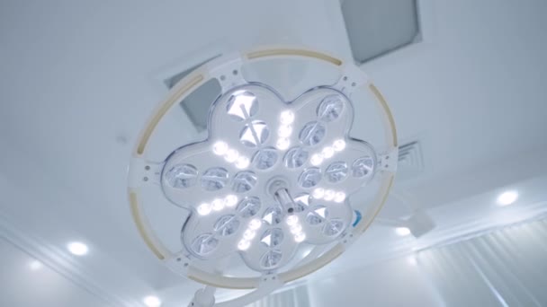 Parlak cerrahi lamba ışığı. Başla. Ameliyathanede büyük bir lambanın kör edici ışığı. Ameliyat lambası anestezi sırasında parlak ışıkla kör eder. — Stok video