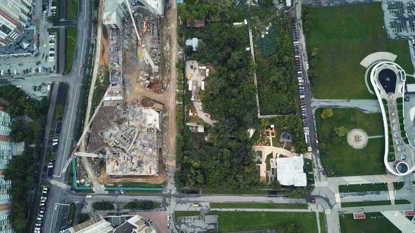 Vista aérea superior de uma zona industrial na área da cidade localizada pelo parque verde, conceito de ecologia. Imagens de stock. Voando acima do canteiro de obras e árvores verdes. — Fotografia de Stock