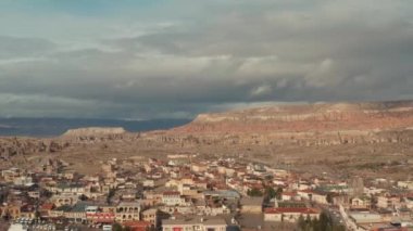 Güneşli bir yaz gününde güneşli bir güney şehrinin havadan panoramik görüntüsü. Başla. Arka plandaki kuru dağlarda birçok küçük ev ve dar sokaklar.