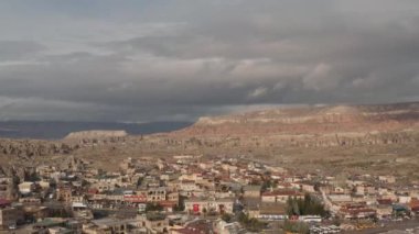 Güneşli bir yaz gününde güneşli bir güney şehrinin havadan panoramik görüntüsü. Başla. Arka plandaki kuru dağlarda birçok küçük ev ve dar sokaklar.