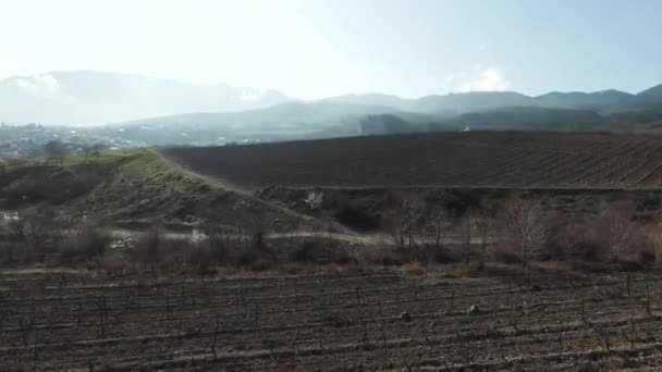 Panoramautsikt över jordbruksfälten på landsbygden och landsbygden. Skjuten. Vackra jordbruksmark efter plantering med kullar och blå himmel på bakgrunden. — Stockvideo