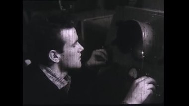 Rusya - Novorossiysk, 04.25.2021: Kimya fabrikasında çalışan genç Sovyet bilim adamlarının geçmişi. Stok görüntüleri. Mikroskopla bakan genç bir adam, kadın ve erkeklerden oluşan bir ekip