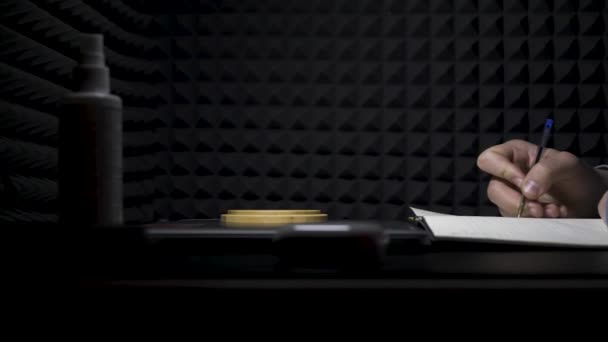 Concept d'écriture de chansons, vue de côté d'un homme écrivant des paroles dans un studio de musique professionnel. HDR. Processus de création d'une chanson par l'auteur, musicien écrivant du texte sur une feuille de papier. — Video