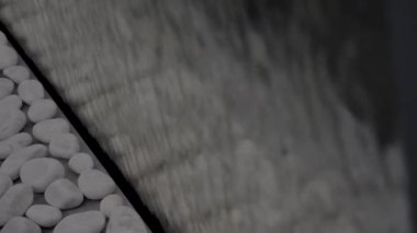 İç dizayn detayları, yapay şelale duvarı ve beyaz taşlar. HDR. Suyun duvardan aşağı akması, sakin bir atmosfer, tasarım ve meditasyon konsepti yaratır..