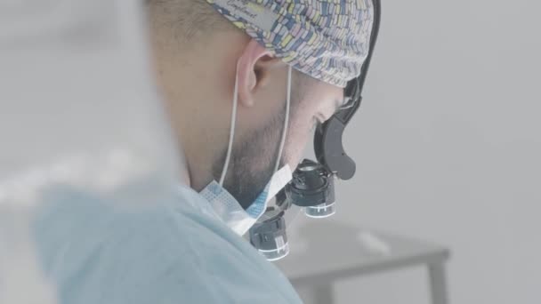 Chirurg mit Fernglasbrille bei der Operation. Handeln. Moderne Technologien in Medizin und Chirurgie. Brille mit Vergrößerung und Licht für chirurgische Operationen — Stockvideo