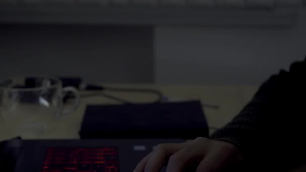 Vista laterale ravvicinata di un uomo d'affari o programmatore che digita sulla tastiera di un computer portatile presso una scrivania in ufficio. HDR. Braccia maschili di un manager che lavora fino a tarda notte. — Video Stock