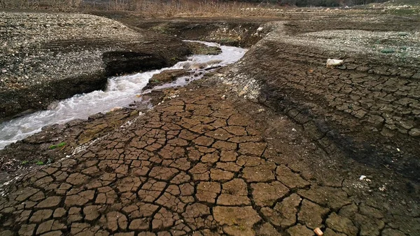 水流成河的干地景观.开枪了有裂缝和狭窄河流的田野的空中景观，生态和全球变暖的概念. — 图库照片