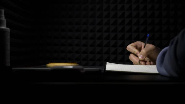 Concepto de composición, vista lateral de un hombre escribiendo letras en un estudio de música profesional. HDR. Proceso de creación de una canción del autor, músico escribiendo texto en una hoja de papel. —  Fotos de Stock