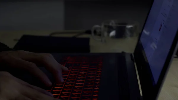 Un uomo d'affari premuroso al lavoro con un computer portatile a tarda sera in ufficio, concetto di stacanovista. HDR. Uomo serio pensieroso guardando il monitor del suo computer e digitando. — Foto Stock