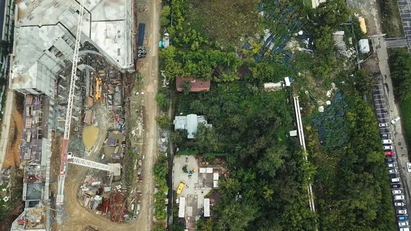 Vista aérea de una zona industrial en el área de la ciudad ubicada por parque verde, concepto de ecología. Imágenes de archivo. Volando por encima del sitio de construcción y árboles verdes. —  Fotos de Stock