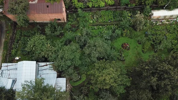 Aldeia no distrito rural com vegetação e casas pequenas velhas. Imagens de stock. Vista aérea superior da paisagem rústica com um jardim e gramado verde. — Fotografia de Stock