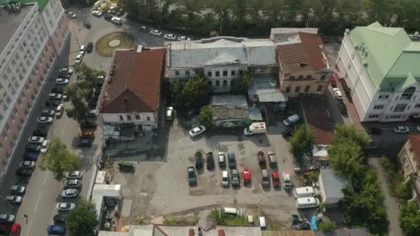 Luchtfoto van een binnenplaats met lelijke gevels van huizen en veel geparkeerde auto 's. Voorraadbeelden. Parkeerplaats gelegen bij de verlaten oude huizen en administratief gebouw. — Stockvideo