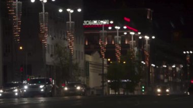 Güzel sokak lambaları ve arabaları olan bir gece şehri. Stok görüntüleri. Bir sürü ışıklandırması ve arabası olan canlı bir gece şehri. Güzel ışıklandırılmış gece şehri