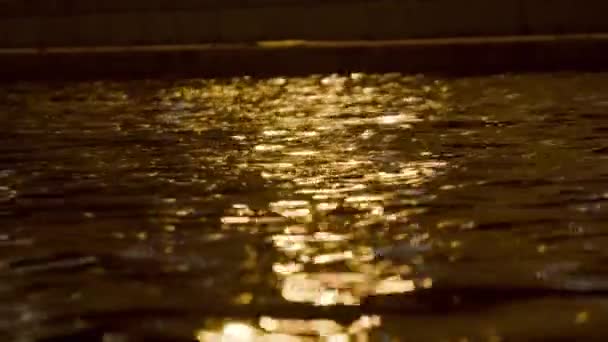 A luz de lanternas reflete-se no canal de cidade à noite. Imagens de stock. A luz da cidade noturna reflete-se em águas do canal de cidade. Águas escuras de canais de cidade com reflexão de luz de rua — Vídeo de Stock