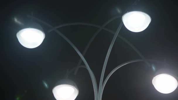 Pouliční lampa se čtyřmi lampami. Záběry ze skladu. Moderní design pouliční lampy na pozadí noční oblohy. Světelná pouliční lampa v noci — Stock video