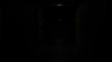 Yeşil, gri duvarları ve yanıp sönen ışığı olan uzun bir koridor. HDR. Elektrik kesintisi, ofis binasında karanlık bir koridor..