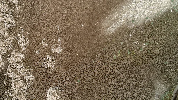 Aerial view of a bottom of a dried lake, concept of global warming and climate disaster. Shot. Dry brown soil with deep cracks. — Stock Photo, Image