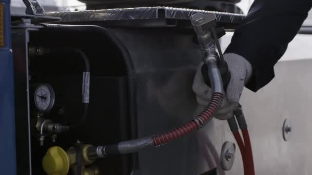 Närbild av arbetare händer i skyddshandskar med hjälp av en ny kompressor för däck pumpning. På plats. Professionell utrustning i en serviceverkstad. — Stockvideo