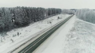 Açık bir kış gününde bir demiryolu boyunca giden bir B yük kamyonunun hava görüntüsü. Kargo kamyonları Utah 'taki engebeli karlı çölde konteynır taşıyorlar..