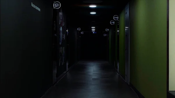 Длинный коридор с зелеными и серыми стенами и мигающим светом. HDR. Отказ электричества, интерьер темного коридора в офисном здании. — стоковое фото