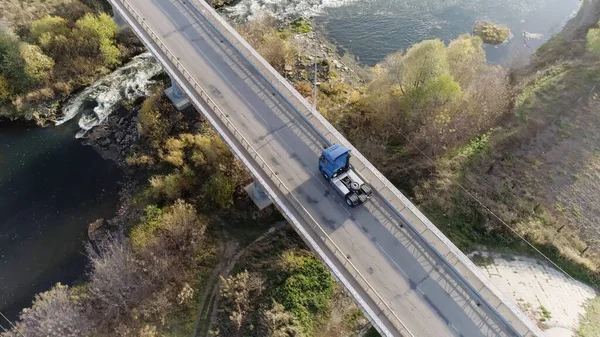 Légi felvétel egy kamionról, amint áthajt a hídon a tó felett. Jelenet. Autópálya-összeköttetés a közlekedéssel. — Stock Fotó