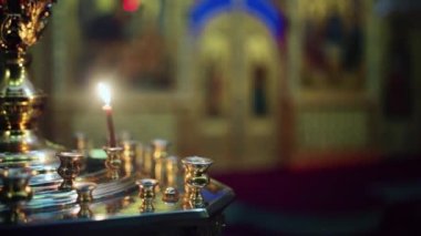 Dua mumları. Rus Ortodoks Hıristiyan Kilisesi 'nde mum tutucusu. Sahne. Kum şamdanlarındaki kilise mumları İkonların arka planında boş iç mekanlarda, Hıristiyanlığın dini ayinlerinde