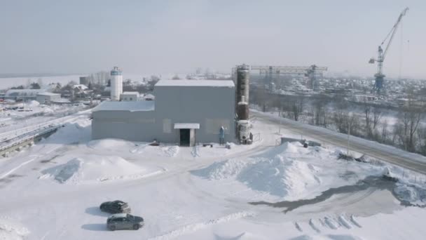 Magazyn przemysłowy w zimowy słoneczny dzień. Klip. Widok z lotu ptaka na przemysłową strefę miejską i plac budowy. — Wideo stockowe