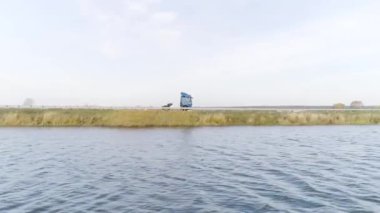 Kamera dalgalı nehir boyunca arka planda bir sürücü kamyonu ile uçuyor. Sahne. Tarlalar boyunca giden bir kamyonun ve kırsal alanda akan bir nehrin havadan görüntüsü..