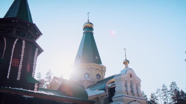 Luchtfoto van een orthodoxe kerk exterieur in klooster met gouden koepels en kruisen op blauwe heldere hemel achtergrond. Een video. Begrip religie en geloof — Stockvideo