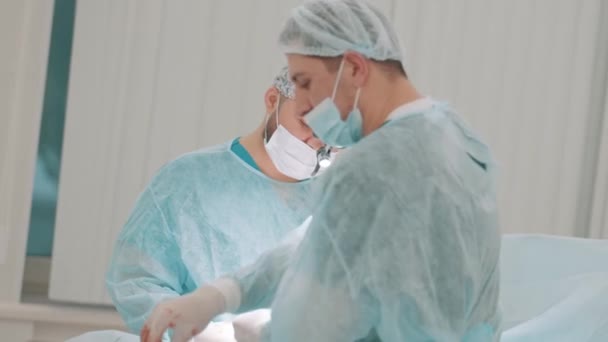 Operaci provádějí dva profesionální lékaři v lékařských maskách a čisté uniformě. Akce. Koncepce zdravotní péče a medicíny. — Stock video