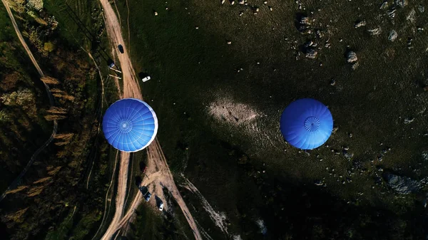 Вид сверху на два разноцветных воздушных шара в сельской местности. Выстрел. Полет Аэростата над полями и камнями, концепция приключений. — стоковое фото