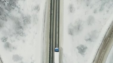 Şiddetli hava koşullarında kış ormanından geçen yoldaki hava trafiği. Sahne. Kargo kamyonu karla kaplı ağaçlarla çevrili düz bir yolda ilerliyor..