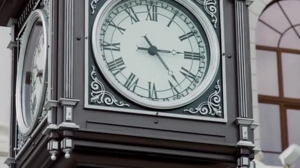 Hermosa torre reloj al aire libre en la calle de la ciudad. Vídeo. Concepto de arquitectura vintage, antigua torre del reloj con números romanos. — Vídeo de stock
