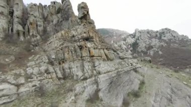 Dağların kayalık arazisinin en üst manzarası. Vuruldu. Çok çeşitli rahatlamalarla kayalık dağ yamaçlarında uçmak. Dağlık arazide kayaların çeşitliliği ve erozyon gidericiler