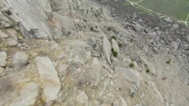 Kayalık kayalıklardan in. Vuruldu. Güneşli bir günde, kayalık dağın yamacından aşırı hızlı bir uçuş. Atlayış tulumundan ya da kayalık yamaçlara dalış yapan kuadrokopterden