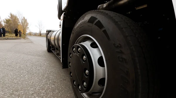 Gros plan du camion de fret blanc qui passe sur l'autoroute. Scène. Vue détaillée de la roue du camion et du roulement des pneus sur asphalte sec de l'autoroute. — Photo