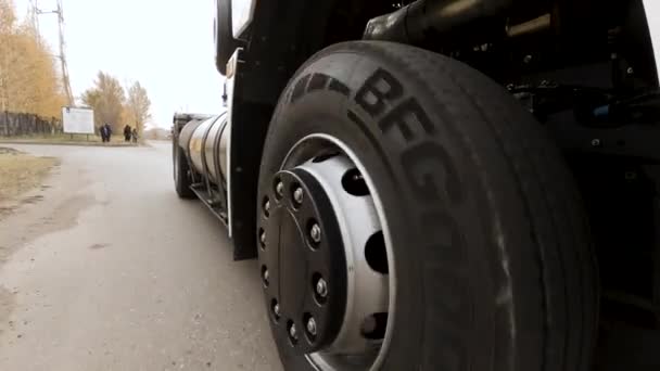 Close up de caminhão de carga branca passando pela estrada. Cena. Vista em detalhe da roda do caminhão e pneu rolando no asfalto auto-estrada seca. — Vídeo de Stock