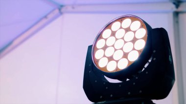 Beyaz duvar arka planında dönen parlak bir soffit. Video kaydı. Fotoğraf ya da video stüdyosundaki profesyonel ekipmanlar.