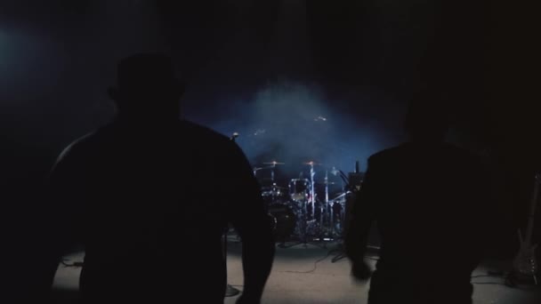 Rückansicht einer männlichen Rock- oder Metalband, die mit Instrumenten und Rauch auf der dunklen Bühne läuft. Video. Konzept der Musikkunst, Vorbereitungen für das Konzert. — Stockvideo