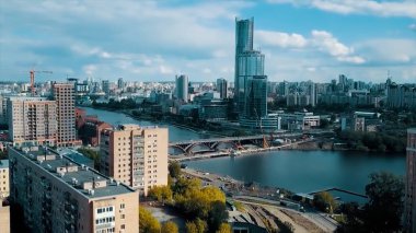Moskova 'nın merkez caddelerindeki güzel bir şehir, gökdelen ve diğer binaların hava manzarası. Video kaydı. Mimari elementleri olan güzel bir şehir, köprüsü ve mavi bulutlu gökyüzü olan bir nehir..