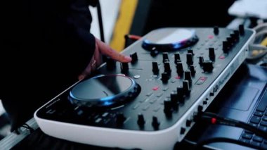 Gece kulübü disko partisinde DJ karıştırıcı masasını kapat. Video kaydı. DJ el sürgüye dokunur, elektronik müzik çalar..