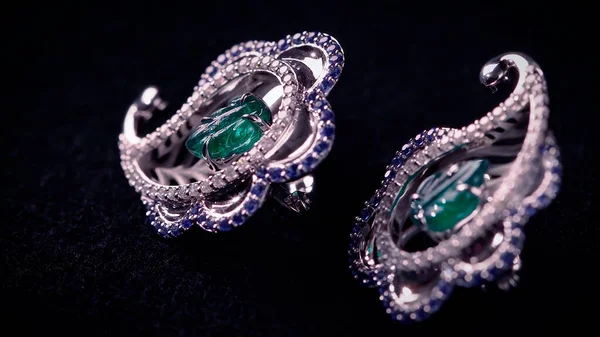 Close up of antique earings made of platinum, diamonds and giant emerald. Video. Luxury jewelry with gem stones isolated on black background. — Stok Foto