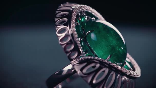 Zblízka stříbrný prastarý prsten s velkým smaragdem. Video. Úžasný retro prsten, historický klenot izolovaný na tmavém pozadí. — Stock video