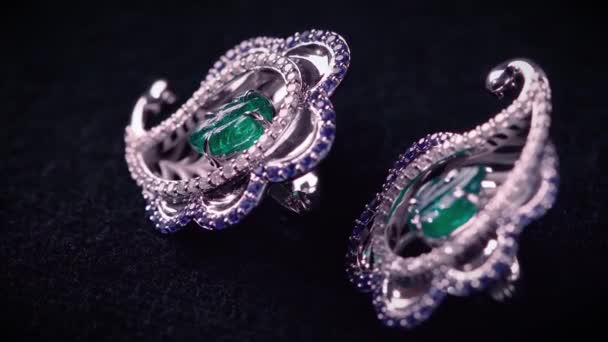 Gros plan de boucles d'oreilles antiques en platine, diamants et émeraude géante. Vidéo. Bijoux de luxe avec pierres précieuses isolées sur fond noir. — Video